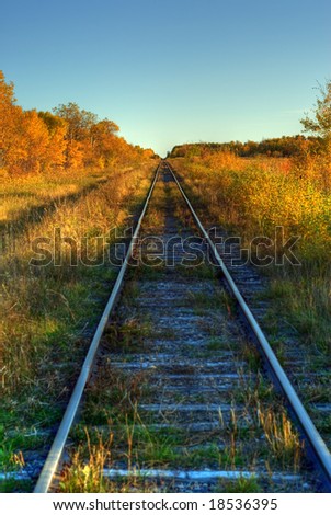 A set of railroad tracks running across the country shot in HDR