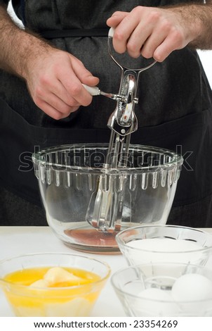 A man using a hand mixer to mix baking ingredients