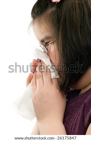 Closeup view of a young girl blowing her nose, shot on a profile view, isolated against a white background