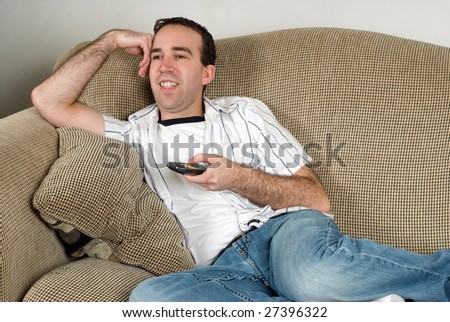 A young man watching tv and relaxing after a day at work