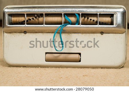 A vacuum beater brush is tangled with hair and an rubber band