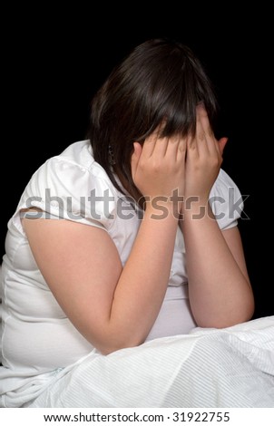 stock photo A young preteen girl sitting in the dark and crying with her 