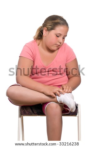 stock photo A young preteen girl is sitting on a stool and putting on her