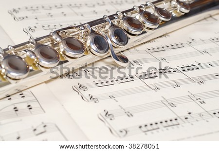 Closeup view of a metal wind instrument shot on a music sheet