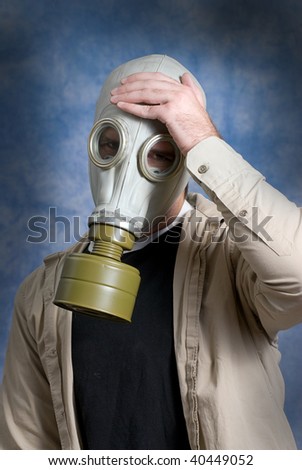 Concept image of a young man suffering from a headache while wearing a gas mask