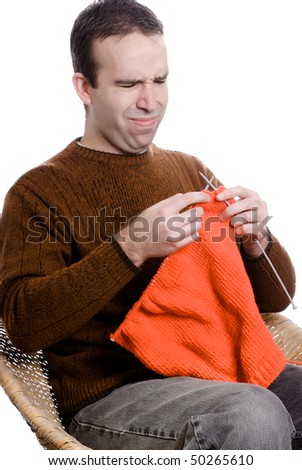 A young man is learning to knit and looks frustrated, isolated against a white background