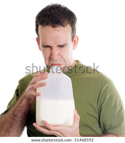Man smelling a container of milk and discovering it is spoiled, isolated against a white background