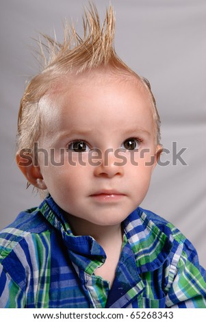 A closeup portrait of a spiky haired boy toddler wearing a nice shirt