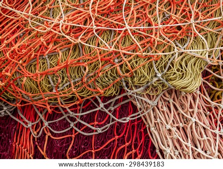 Fishing nets : close-up of fish nets, chains and ropes stacked in the harbor, paying particular attention to the colors, textures, materials, details, knots, etc.