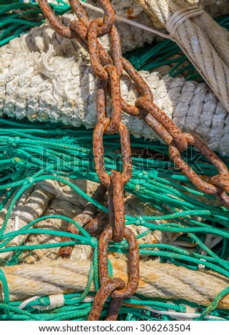 Close-up of fishing nets stacked in the harbor, paying particular attention to the colors, textures, materials, details, knots, etc.