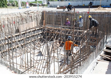 RAYONG, THAILAND-JULY 6:Unidentified Thai people construction workers positioning in place cement formwork frames on July 6,2014 in Rayong, Thailand