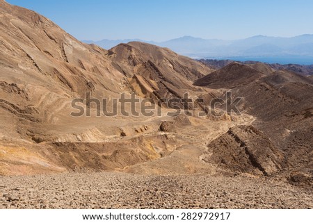 Stone desert mountains cliffs near Eilat Red sea bay, dry riverbeds canyons gorges, Negev desert, Israel.