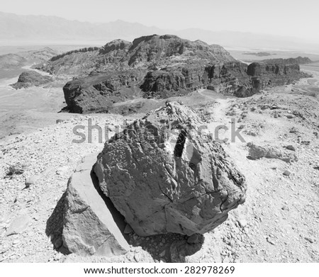 Huge black and white  stone, rock trail marking sign, Negev desert mountains cliffs, Arava, Israel.
