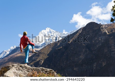 Man sportsman rear view standing one leg on stone, practicing yoga asana in front snow peaks mountains. Everest Base Camp trail route traveling, Himalaya range tourism.
