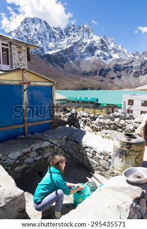 Young woman tourist doing laundry, Gokyo village lodge guesthouse, Gokyo lake, Everest Base Camp route trail trekking, Nepal tourism.