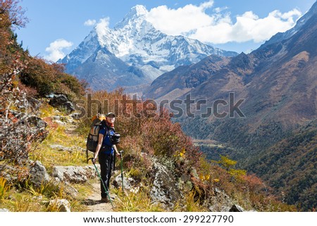 Young woman backpacker tourist standing looking Ama Dablam mountain snow peaks. Everest Base Camp trekking route trail, Nepal traveling tourism.
