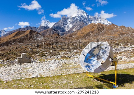 Solar panel cooker heating water kettle, renewable green  energy source, Nepal mountains. Everest Base Camp route trail, Nepal trekking, Himalaya tourism.