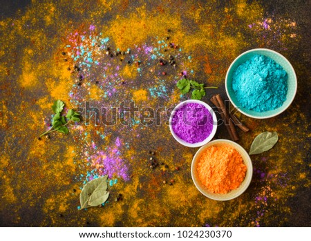 Traditional Indian Holi colours powder, spices, rustic background. Indian Holi holiday. Holi celebration. Top view. Festive Indian table setting. Space for text. Holi concept. Decoration with paints