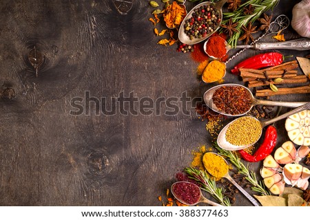 Set of various aromatic colorful spices in old vintage spoons and herbs on a dark wooden background. Space for text. Food frame. Ingredients for cooking. Top view