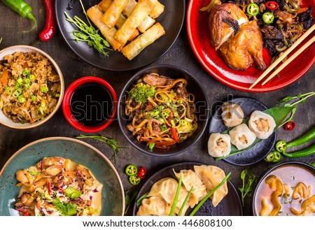 Assorted Chinese food set. Chinese noodles, fried rice, dumplings, peking duck, dim sum, spring rolls. Famous Chinese cuisine dishes on table. Top view. Chinese restaurant concept. Asian style banquet