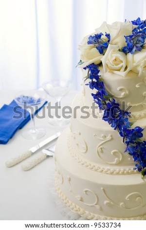  traditional wedding cake decorated with blue delphiniums and white roses
