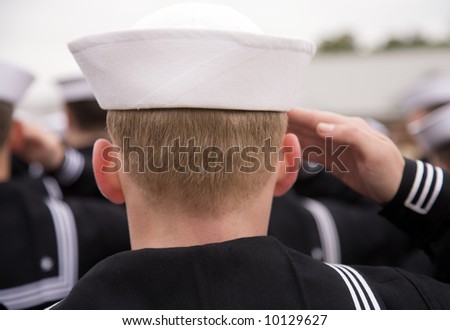 A navel cadet at the training school salutes the flag