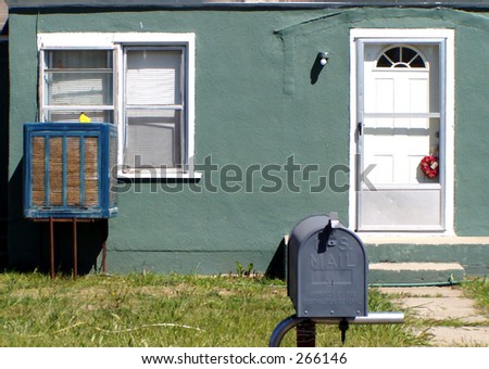 Green house with blue mailbox.