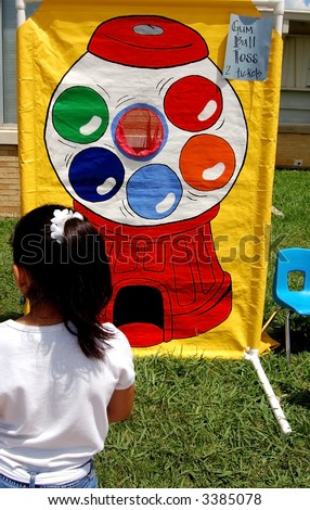 Latina, playing a throwing game at a school carnival.