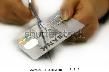 Cutting up a credit card. All numbers and logos are rendered useless.