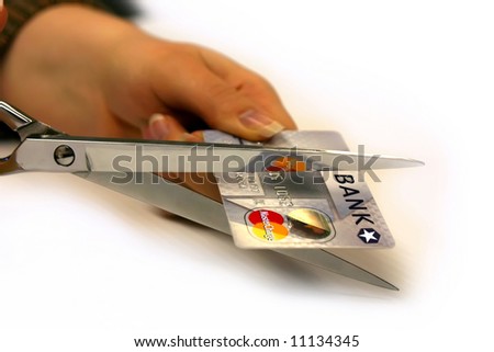 Cutting up a credit card. All numbers and logos are rendered useless.