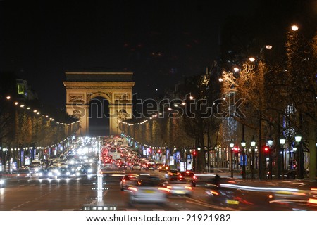 Arc de Triomphe, Paris. Illuminated avenue Champs Elysees by night. Cars traffic