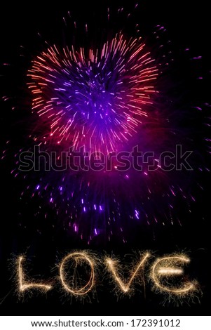 Red fireworks in the night sky in the form of heart and word love.