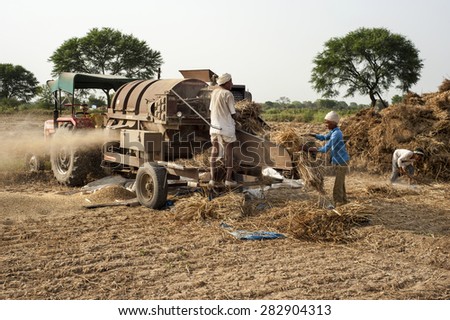 ORCHA,INDIA -  APRIL  23, 2015: Unidentified Indian people working on the field on April  23, 2015 in Orchha, Madhya Pradesh, India. India ranks second worldwide in farm output.
