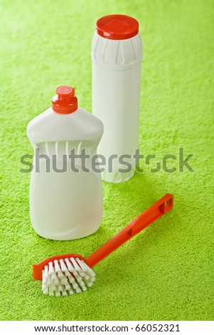 brush and white bottles on green background