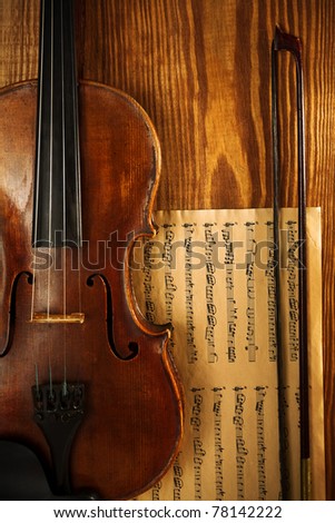 old used violin on wooden board with note