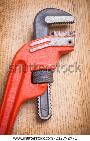 close up view on pipe wrench on wooden board