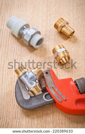 plumbing fixtures and adjustable wrench on wooden board