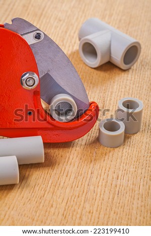 pipe cutter and polypropylene cutted pipes on wooden boards