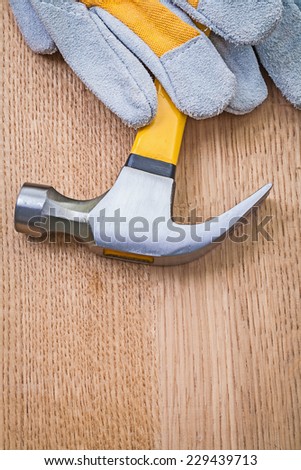 claw hammer and safety glove on wooden board