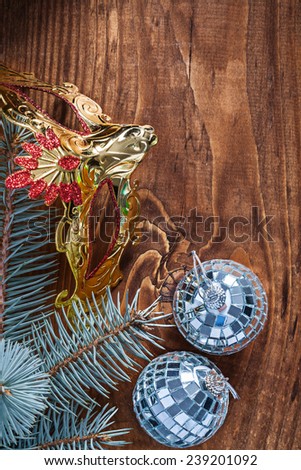 christmas composition mirror disco balls and pinetree branch with golden carnaval mask on old wooden board