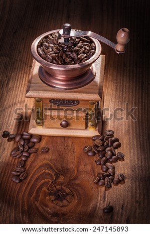 coffee greender with coffee beans on old wooden board