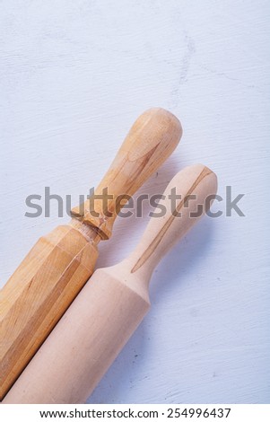 two rolling pins on white painted wooden board