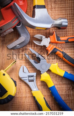 set o f tools on wooden board tapeline adjustable wrench hammer nippers pliers