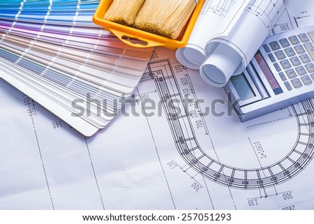 composition of tools stack rolled up white blueprints calculator paintbrushes in paint can