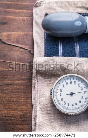 blood pressure monitor on vintage wooden board close up medical comcept
