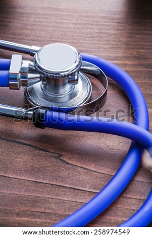 blue medical stethoscope on vintage wooden board