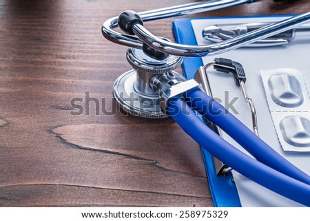 medical stethoscope clipboard pills in pack on vintage wooden board medical comcept