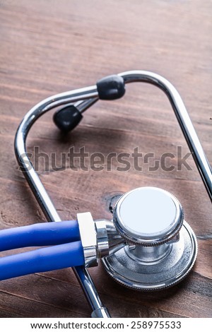 medical stethoscope very close up view on vintage wooden board