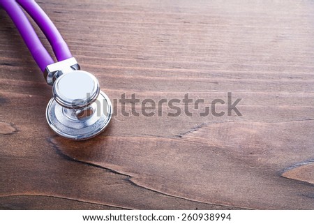 head of stethoscope on vintage wooden board with organized copyspace medical concept