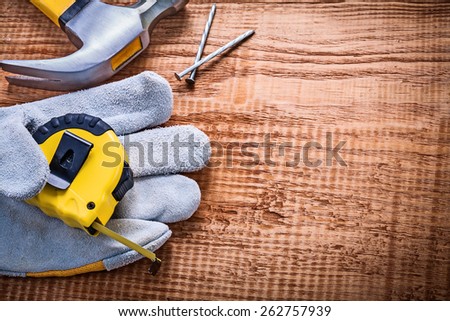 yellow roulette in protective glove hammer nails on vintage wooden board construction concept